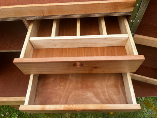 Handy drawers Open wooden drawer with dividers, showcasing a smooth interior.